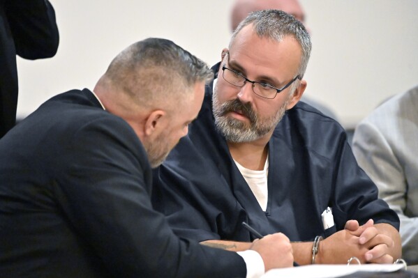 CORRECTS TO HEARING, INSTEAD OF ARRAIGNMENT - Former Letcher County Ky. Sheriff Shawn "Mickey" Stines, right, confers with his attorney, Jeremy Bartley, during a hearing at the Morgan County Courthouse in West Liberty, Ky., Tuesday, Oct. 1, 2024. Stines has been charged in the shooting death of Kentucky District Judge Kevin Mullins. (AP Photo/Timothy D. Easley)
