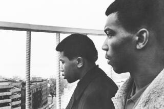 FILE - James Alexander, left, and Carl Simms, both of Memphis, Tenn., view from atop Madison hotel in Madison, Wis., Dec. 11, 1967, the lake in which the plane bearing singer Otis Redding and seven others crashed. Alexander and Simms, members of rhythm and blues group called the Bar-Kays, were unable to board Redding's private plane in Cleveland because of lack of space. The crash was believed to have claimed-seven of eight persons aboard, including Redding. Alexander, the last surviving member of The Bar-Kays band that backed soul music star Otis Redding, will have a street renamed after him in his hometown of Memphis, Tennessee, Stax Museum said. (AP Photo/File)
