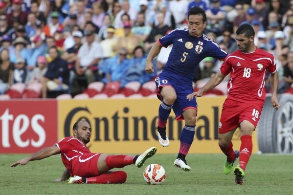 FILE - Palestine's Musab Battat, right, and Ismail Alamour compete for the ball with Japan's Yuto Nagatomo, center, during the AFC Asia Cup soccer match between Japan and Palestine in Newcastle, Australia, Monday, January 12, 2014. (AP Photo/Rob Griffith, File)