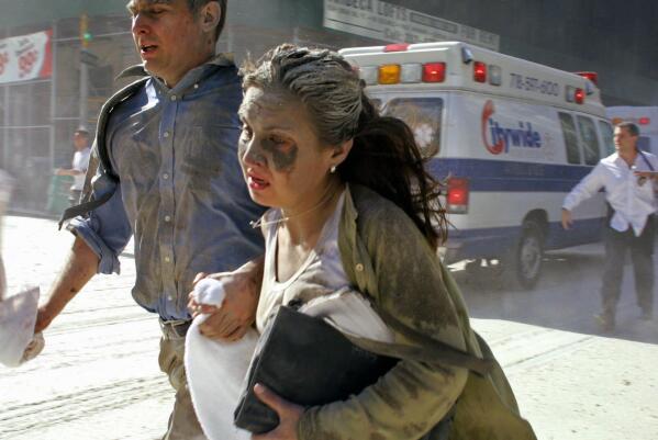 People flee the scene near New York's World Trade Center Tuesday, Sept. 11, 2001. (AP Photo/Diane Bondareff)