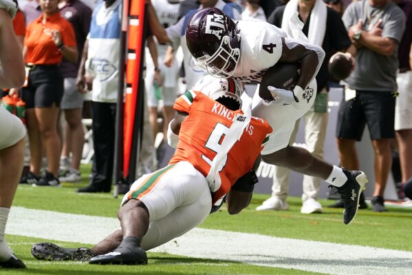 Texas A&M running back Amari Daniels (4) is tackled by Miami safety Kamren Kinchens (5) during the first half of an NCAA college football game Saturday, Sept. 9, 2023, in Miami Gardens, Fla. (AP Photo/Lynne Sladky)