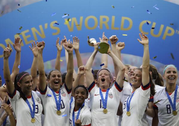 FILE - United States' Megan Rapinoe lifts up the trophy after winning the Women's World Cup final soccer match between US and The Netherlands at the Stade de Lyon in Decines, outside Lyon, France, in July 7, 2019. The U.S. Soccer Federation reached milestone agreements to pay its men's and women's teams equally, making the American national governing body the first in the sport to promise both sexes matching money. (AP Photo/Alessandra Tarantino, File)