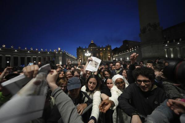 Copies of the Vatican paper L'Osservatore Romano are distributed after a rosary prayer for the late Pope Francis, in St. Peter's Square at the Vatican, Monday April 21, 2025. (AP Photo/Alessandra Tarantino)