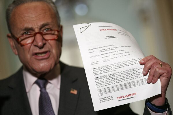 Senate Minority Leader Sen. Chuck Schumer of N.Y. holds up a copy of a White House released rough  transcript of a phone call between President Donald Trump and the President of Ukraine as Schumer speaks to the media about an impeachment inquiry on President Trump, Wednesday Sept. 25, 2019, on Capitol Hill in Washington. (AP Photo/Jacquelyn Martin)