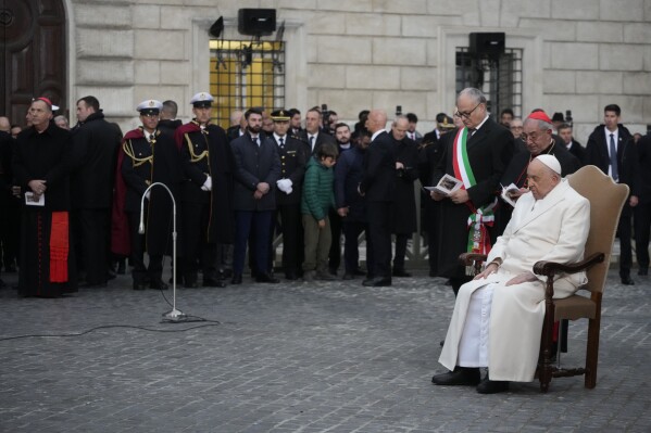 Pope Francis, right, is flanked by, from right, his vicar Cardinal Angelo Comastri, and Rome's Mayor Roberto Gualtieri during his annual Christmas visit to venerate a statue of the Virgin Mary near the Spanish Steps in Rome, Friday, Dec. 8, 2023. (AP Photo/Gregorio Borgia)