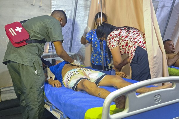 Yorvis Hernandez, a 34-year-old miner, gets medical attention at at tent set up next to a mine after it collapsed in La Paragua, Bolivar state, Venezuela, Wednesday, Feb 21, 2024. (AP Photo/Andrea Calma)