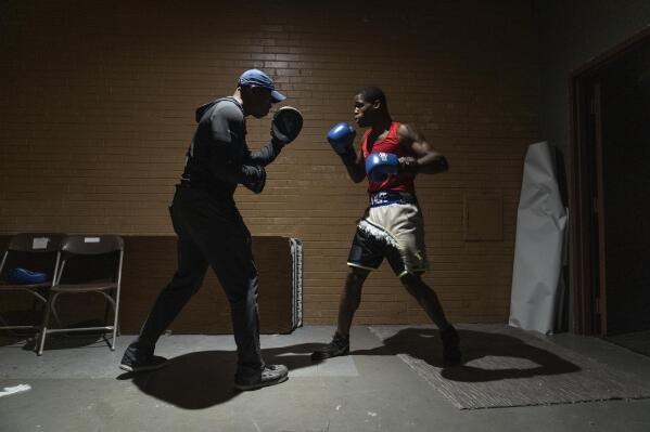 Theon Davis, 21, right, who fights at the 176-pound weight class, warms up with Arustus Muhammad as he prepares for his bout on a night of quarter-final boxing matches at the Chicago Golden Gloves tournament Thursday, March 16, 2023, at Cicero Stadium in Cicero, Ill. Davis, ranked No. 3 at 176 pounds by USA Boxing, is one of 470 fighters who entered the 100th edition of the Chicago Golden Gloves tournament, a storied event that counts Joe Louis, Sonny Liston and Muhammad Ali - when he was Cassius Clay - as past champions. (AP Photo/Erin Hooley)