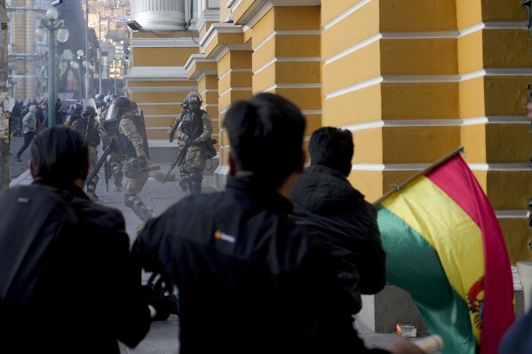 Supporters of President Luis Arce chase soldiers as they flee from Plaza Murillo, after a failed coup attempt in La Paz, Bolivia, Wednesday, June 26, 2024. Armored vehicles rammed into the doors of Bolivia’s government palace located in Plaza Murillo as Arce said the country faced an attempted coup. (AP Photo/Juan Karita)
