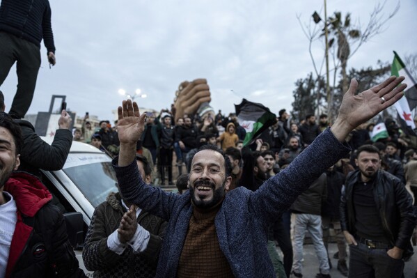 People gather to celebrate the fall of the Syrian government, in Manbij, Syria, Sunday, Dec. 8, 2024. (Ugur Yildirim/Dia Photo via AP)