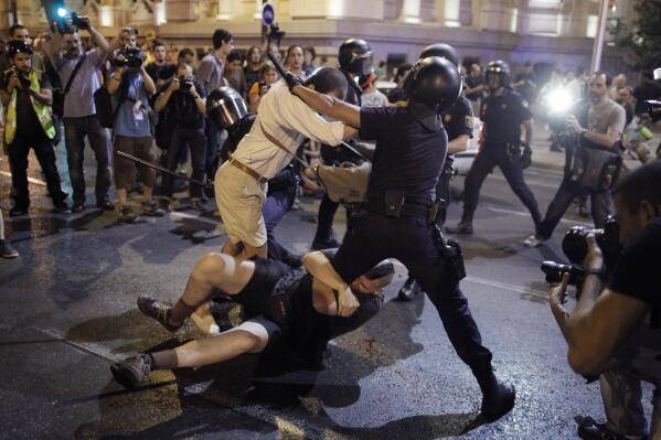 Police clash with protestors during a demonstration against the government in front of the People's Party headquarter in Madrid, Spain, Thursday, July 18, 2013. Spain’s Prime Minister on Monday brushed off demands he should resign after text messages emerged showing he had a cozy relationship with a disgraced political party treasurer who amassed 47 million euros ($61 million) in secret Swiss bank accounts. The spectacle of alleged greed and corruption has enraged Spaniards hurting from austerity and sky high unemployment with no end in sight. (AP Photo/Andres Kudacki)