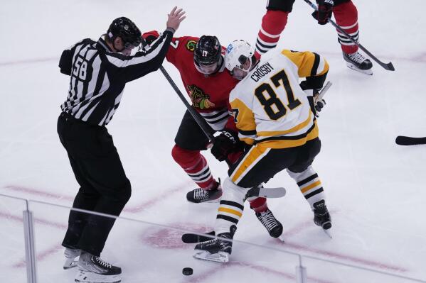 Chicago Blackhawks center Jason Dickinson and Pittsburgh Penguins center Sidney Crosby (87) battle for the puck during the second period of an NHL hockey game in Chicago, Sunday, Nov. 20, 2022. (AP Photo/Nam Y. Huh)