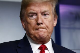 President Donald Trump listens as Agriculture Secretary Sonny Perdue speaks about the coronavirus in the James Brady Press Briefing Room of the White House, Friday, April 17, 2020, in Washington. (AP Photo/Alex Brandon)