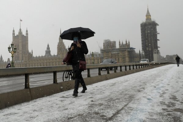 A woman walks over Westminster Bridge as temperatures dropped below freezing during the third coronavirus lockdown in London, Tuesday, Feb. 9, 2021. (AP Photo/Kirsty Wigglesworth)