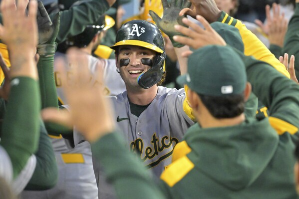 Athletics Jacob Wilson is congratulated in the dugout after hitting a 3-run home run during the third inning of a baseball game against the Los Angeles Dodgers, May 13, 2025, in Los Angeles. (AP Photo/Jayne Kamin-Oncea)