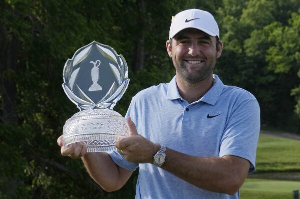 Scottie Scheffler poses for a photo with the trophy after winning the Memorial golf tournament, Sunday, June 9, 2024, in Dublin, Ohio. (AP Photo/Sue Ogrocki)