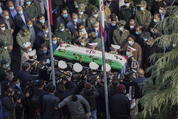 In this photo released by the official website of the Iranian Defense Ministry, military personnel carry the flag draped coffin of Mohsen Fakhrizadeh, a scientist who was killed on Friday, in a funeral ceremony in Tehran, Iran, Monday, Nov. 30, 2020. Iran held the funeral service for Fakhrizadeh, who founded its military nuclear program two decades ago, with the Islamic Republic's defense minister vowing to continue the man's work "with more speed and more power." (Iranian Defense Ministry via AP)