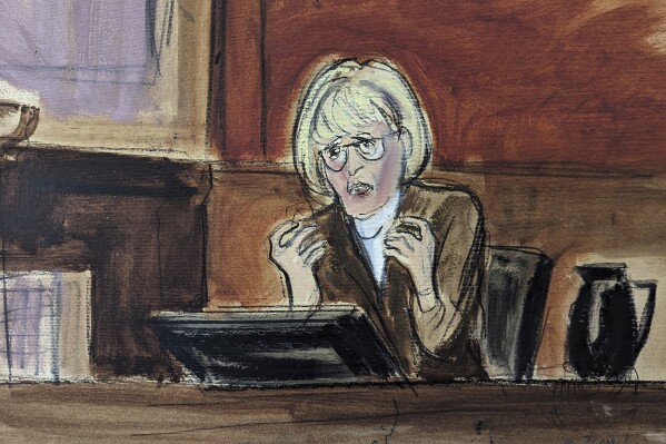 In this courtroom sketch, E. Jean Carroll testifies on the witness stand in Federal Court, in New York, Wednesday, Jan. 17, 2024. Carroll stated that Donald Trump's vitriol toward her has not ceased, pointing to multiple social media posts he made about her in recent days, and that his rhetoric continues to inspire venom against her from strangers because she claimed he sexually abused her decades ago. (Elizabeth Williams via AP)