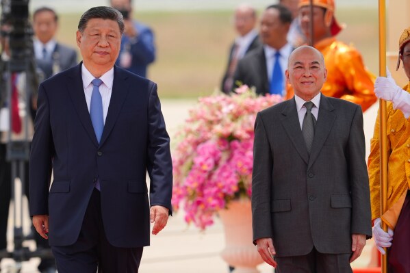 In this photo released by Agence Kampuchea Press (AKP), Cambodia's King Norodom Sihamoni, right, and Chinese President Xi Jingping attend a welcome ceremony at Phnom Penh International Airport in Phnom Penh, Cambodia, Thursday, April 17, 2025. (AKP via AP)