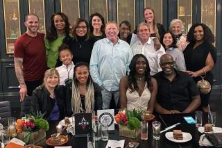 This photo provided by Sylvia Crawley Spann, shows former WNBA player Sylvia Crawley Spann and her husband Brian, seated bottom right, celebrating their wedding with Las Vegas Aces WNBA basketball team owner Mark Davis, standing at center, and other former members of the franchise and their guests at a restaurant in Las Vegas on May 29, 2021. Mark Davis has already left his imprint on the Las Vegas Aces franchise in his first year as the team's owner, connecting it's past to the present. Davis has been inviting back alums of the franchise dating to its time in Utah and San Antonio. (Sylvia Crawley Spann via AP)