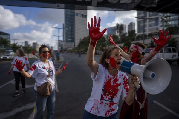 Mothers of Israeli soldiers who serve in Gaza hold up their hands, painted red to symbolize blood, and block a road during a protest calling to end the war, in Tel Aviv, Israel, Wednesday, May 29, 2024. (AP Photo/Oded Balilty)