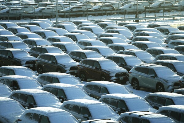 Snow covered vehicles sit in a rental car parking lot at the O'Hare International Airport in Chicago, Sunday, Jan. 14, 2024. Wind chill warning is in effect as dangerous cold conditions continue in the Chicago area. (AP Photo/Nam Y. Huh)