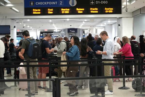 Travelers wait at a TSA checkpoint at Miami International Airport, Thursday, May 23, 2024, in Miami. A record number of Americans are expected to travel over the 2024 Memorial Day holiday. (AP Photo/Lynne Sladky)