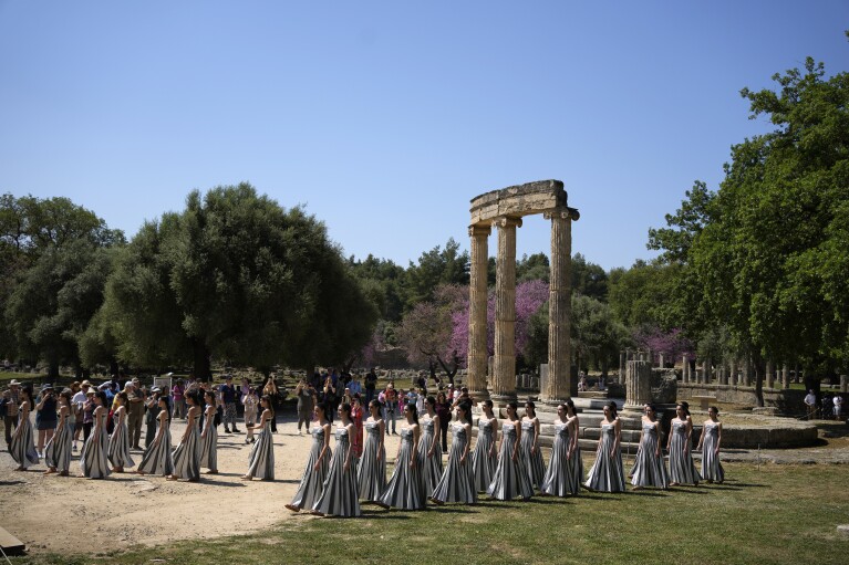 Performers, who will take part in the flame lighting ceremony for the Paris Olympics, join a rehearsal at Ancient Olympia site, Greece, Sunday, April 14, 2024. Every two years, a countdown to the Olympic games is launched from its ancient birthplace with a flame lighting ceremony in southern Greece at Ancient Olympia. The event is marked with a performance by dancers who assume the role of priestesses and male companions, their movement inspired by scenes on millennia-old artwork. (AP Photo/Thanassis Stavrakis)