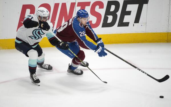 Seattle Kraken right wing Jordan Eberle, back right, fights for control of  the puck with Colorado Avalanche left wing J.T. Compher, back left, as  Avalanche center Lars Eller (20) comes in to