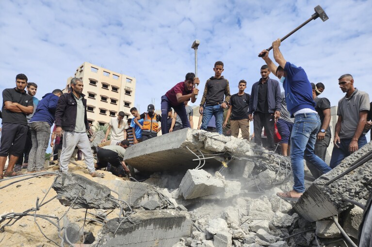Người Palestine tìm kiếm những người sống sót trong các tòa nhà bị phá hủy bởi các cuộc không kích của Israel ở Deir el-Balah, phía nam Dải Gaza, Thứ Ba, ngày 17 tháng 10 năm 2023. (Ảnh AP / Hassan Eslaiah)