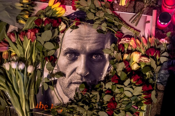 Flowers and a photo of Russian opposition leader Alexei Navalny are placed near the Russian consulate in Frankfurt, Germany, Saturday, Feb. 17, 2024. Navalny, who crusaded against official corruption and staged massive anti-Kremlin protests as President Vladimir Putin's fiercest foe, died Friday in the Arctic penal colony where he was serving a 19-year sentence, Russia's prison agency said. He was 47. (AP Photo/Michael Probst)