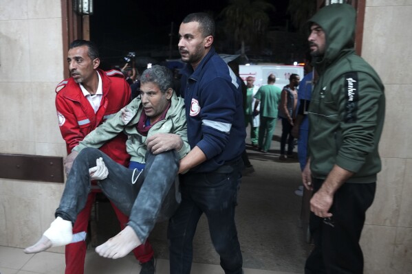 Palestinians wounded in the Israeli bombardment of the Gaza Strip are brought to the hospital in Deir al Balah, Gaza Strip, on Tuesday, Dec. 19, 2023. (AP Photo/Adel Hana)