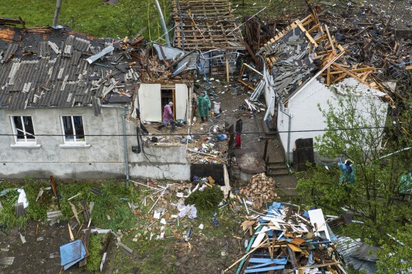 People clear the rubble of residential houses destroyed by a Russian strike in Korostyshiv, Zhytomyr region, Ukraine, Sunday, May 25, 2025. (AP Photo/Evgeniy Maloletka)