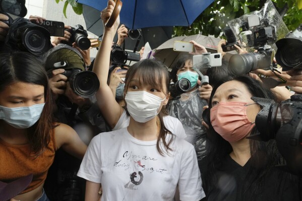 FILE- Agnes Chow, center, a prominent pro-democracy activist who was sentenced to jail for her role in an unauthorized protest, is released in Hong Kong Saturday, June 12, 2021. One of Hong Kong’s best-known pro-democracy activists, who moved to Canada to pursue further studies, said she would not return to the city to meet her bail conditions, becoming the latest politician to flee Hong Kong under Beijing's crackdown on dissidents.(AP Photo/Vincent Yu, File)