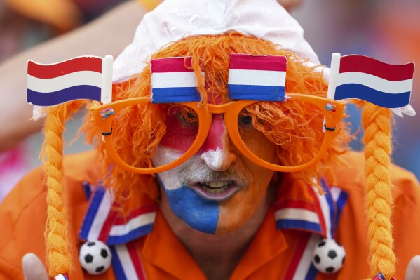 A fan of the Dutch soccer team poses for photos prior to a Group D match between Poland and the Netherlands at the Euro 2024 soccer tournament in Hamburg, Germany, Sunday, June 16, 2024. (AP Photo/Sunday Alamba)