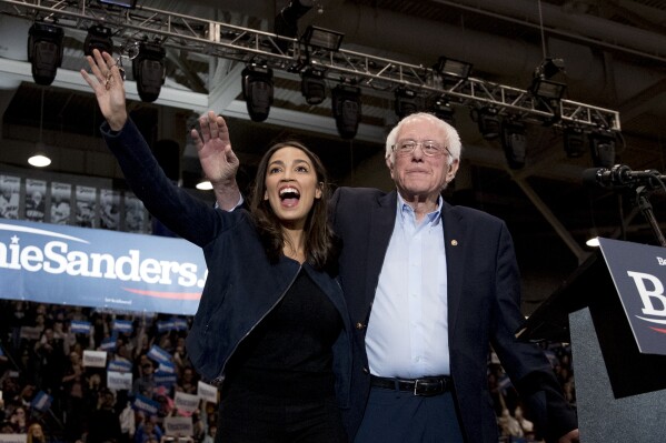 Democratic presidential candidate Sen. Bernie Sanders, I-Vt., accompanied by Rep. Alexandria Ocasio-Cortez, D-N.Y., left, takes the stage at campaign stop at the Whittemore Center Arena at the University of New Hampshire, Feb. 10, 2020, in Durham, N.H. (AP Photo/Andrew Harnik, File)