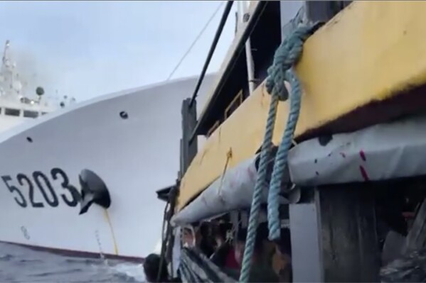 In this image from a video released by the Armed Forces of the Philippines, Filipino sailors, bottom, look after a Chinese coast guard ship with bow number 5203 bumps their supply boat as they approach Second Thomas Shoal, locally called Ayungin Shoal, at the disputed South China Sea on Sunday Oct. 22, 2023. (Armed Forces of the Philippines via AP)