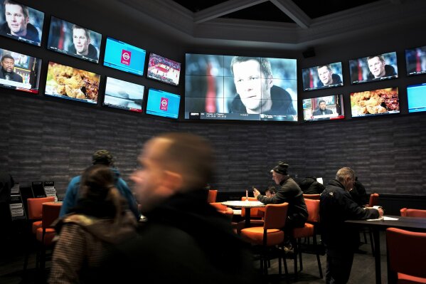 
              FILE - In this Jan. 28, 2019, file photo, patrons visit the sports betting area of Twin River Casino in Lincoln, R.I. Most of the states that moved quickly to legalize sports betting after a Supreme Court decision last year are still waiting for the payoff. Some of those states, like Rhode Island, may have to adjust their budgets to account for lower-than-projected tax revenue. (AP Photo/Steven Senne, File)
            