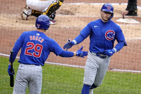 Chicago Cubs' Nico Hoerner, right, is greeted by Michael Busch (29) as he returns to the dugout after hitting a solo home run off Pittsburgh Pirates starting pitcher Paul Skenes during the fourth inning of a baseball game in Pittsburgh, Saturday, May 11, 2024. (AP Photo/Gene J. Puskar)