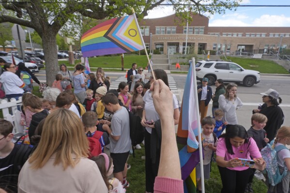 FILE - Bonneville Elementary School parents and students gather during a block party supporting trans and non binary students and staff on April 29, 2024, in Salt Lake City. Transgender activists have flooded a Utah tip line created to alert state officials to possible violations of a new bathroom law with thousands of hoax reports in an effort to shield trans residents and their allies from any legitimate complaints that could threaten their safety. (AP Photo/Rick Bowmer, File)