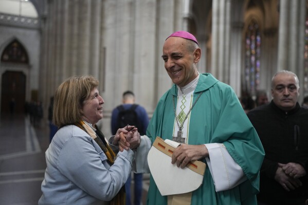 Monsignor Victor Manuel Fernandez, archbishop of La Plata, holds hands with a woman after a Mass at the Cathedral in La Plata, Argentina, Sunday, July 9, 2023. Fernandez was appointed by Pope Francis to head the Holy See's Dicastery for the Doctrine of the Faith at the Vatican. (AP Photo/Natacha Pisarenko)