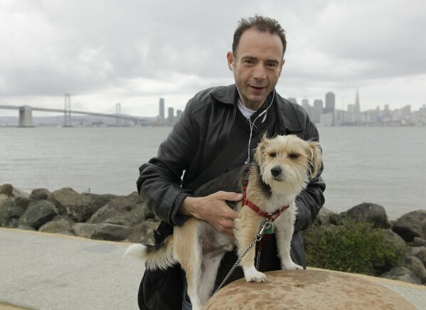 FILE - This May 16, 2011 photo shows Timothy Ray Brown with his dog, Jack, on Treasure Island in San Francisco.  Brown, who was known for years as the Berlin patient, had a transplant in Germany fr...