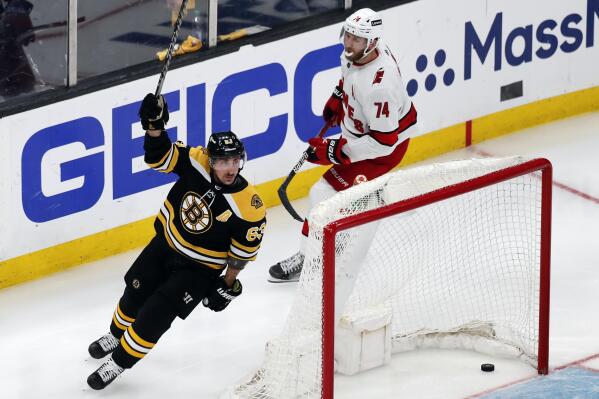Boston Bruins' Brad Marchand (63) celebrates his goal, next to Carolina Hurricanes' Jaccob Slavin (74) during the second period in Game 6 of an NHL hockey Stanley Cup first-round playoff series Thursday, May 12, 2022, in Boston. (AP Photo/Michael Dwyer)
