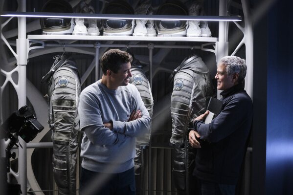 This image released by Netflix shows Kyle Chandler, left, and actor-director George Clooney on the set of "The Midnight Sky." (Philippe Antonello/Netflix via AP)