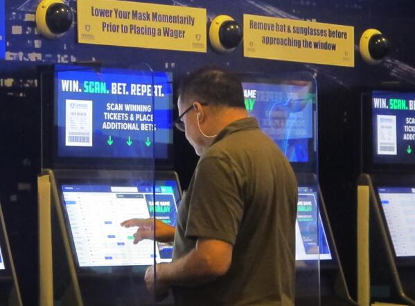 A gambler places a bet at the FanDuel sportsbook in East Rutherford N.J. on Aug. 30, 2021. The American Gaming Association says 45.2 million Americans plan to bet on NFL games this season, up 36% from last year. (AP Photo/Wayne Parry)