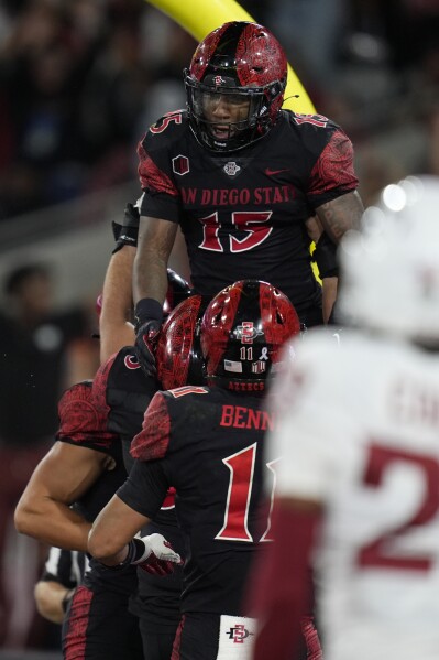 San Diego State running back Marquez Cooper, above, celebrates with teammates after scoring a touchdown during the first half of an NCAA college football game against Washington State Saturday, Oct. 26, 2024, in San Diego. (AP Photo/Gregory Bull)