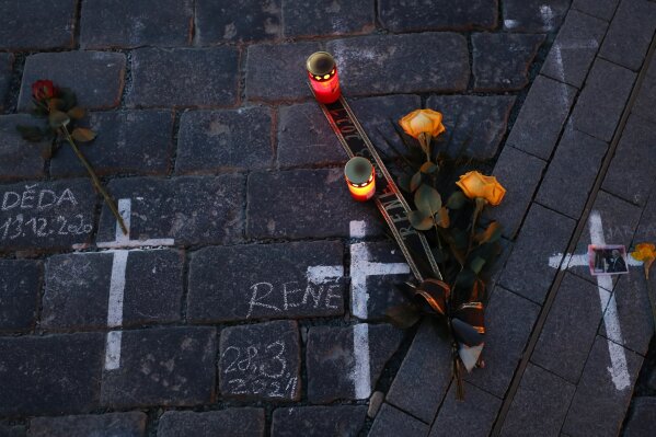 Candles and flowers are placed to pay respect to victims of the COVID-19 pandemic at a spontaneous memorial place set at the Old Town Square in Prague, Czech Republic, Monday, March 29, 2021. The coronavirus pandemic is unleashing enormous suffering as infection rates rise across central Europe even as the Czech Republic and Slovakia, recently among the worst-hit areas in the world, are finally seeing some improvements following tight lockdowns. (AP Photo/Petr David Josek)