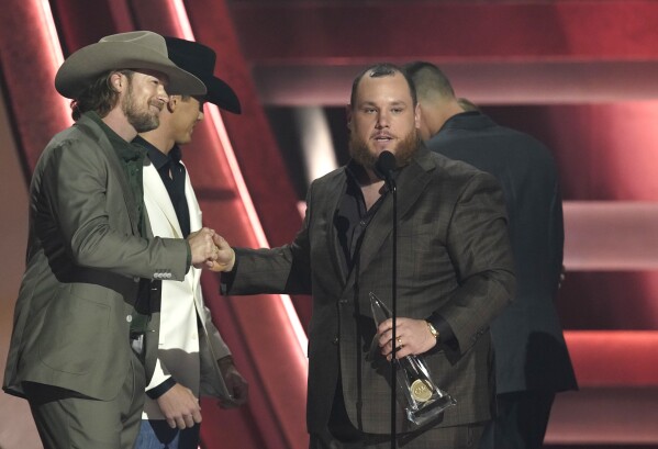 Presenter Brian Kelley, left, shakes hands with Luke Combs as he appears on stage to accept the award for single of the year for "Fast Car" at the 57th Annual CMA Awards on Wednesday, Nov. 8, 2023, at the Bridgestone Arena in Nashville, Tenn. (AP Photo/George Walker IV)