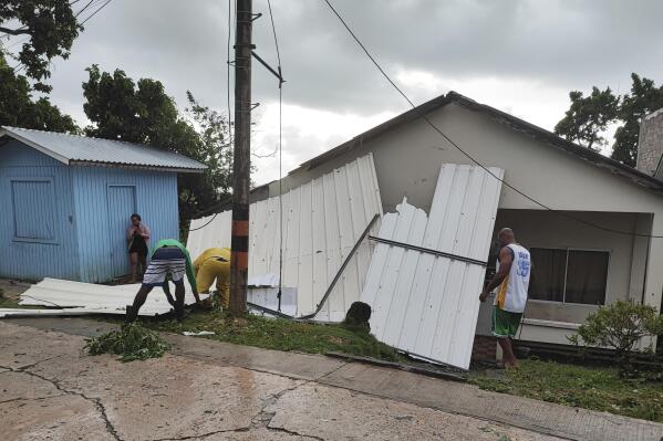 Men pick up a damaged roof in the aftermath of Hurricane Julia in San Andres island, Colombia, Sunday, Oct.9, 2022. Hurricane Julia hit Nicaragua’s central Caribbean coast on Sunday after lashing Colombia’s San Andres island, and a weakened storm was expected to emerge over the Pacific. (AP Photo/Daniel Parra)