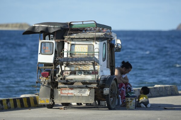 A woman plays with a child at the coastal town of Santa Ana, Cagayan province, northern Philippines on Tuesday, May 7, 2024. The United States and the Philippines, which are longtime treaty allies, have identified the far-flung coastal town of Santa Ana in the northeastern tip of the Philippine mainland as one of nine mostly rural areas where rotating batches of American forces could encamp indefinitely and store their weapons and equipment within local military bases under the Enhanced Defense Cooperation Agreement, or EDCA. (AP Photo/Aaron Favila)
