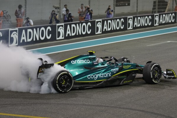 FILE - Aston Martin driver Sebastian Vettel of Germany burns the tires as he finished his last race in career at the Formula One Abu Dhabi Grand Prix, in Abu Dhabi, United Arab Emirates on, Nov.20, 2022. Four-time Formula 1 champion Sebastian Vettel is getting back behind the wheel. Vettel is joining Porsche as a test driver on its Le Mans program and says “we will then see what happens next.” (AP Photo/Kamran Jebreili, File)